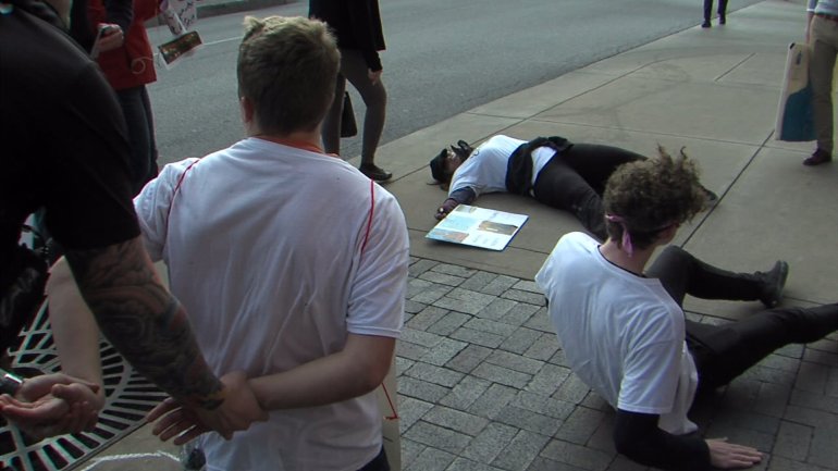 Demonstrators stage a "die-in" on the sidewalk of the Country Club Plaza.
