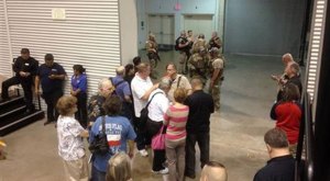 People are sequestered by members of the Garland Police Department inside the Curtis Culwell Center, Sunday, May 3, 2015, in Garland, Texas. A contest for cartoons depictions of the Prophet Muhammad in the Dallas suburb is on lockdown Sunday after authorities reported a shooting outside the building. (Credit: AP Photo/Nomaan Merchant)